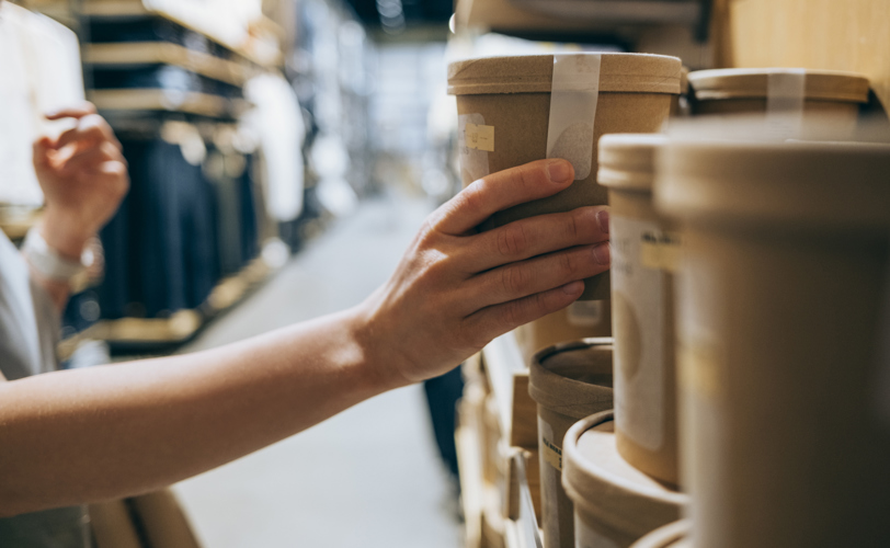 Someone's hand grabbing sustainably packaged product off the shelf