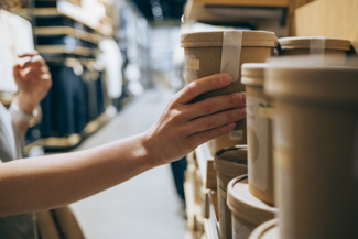 Someone's hand grabbing sustainably packaged product off the shelf